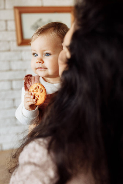 mother and daughter with cookie in the kitchen - Fotoğraf, Görsel