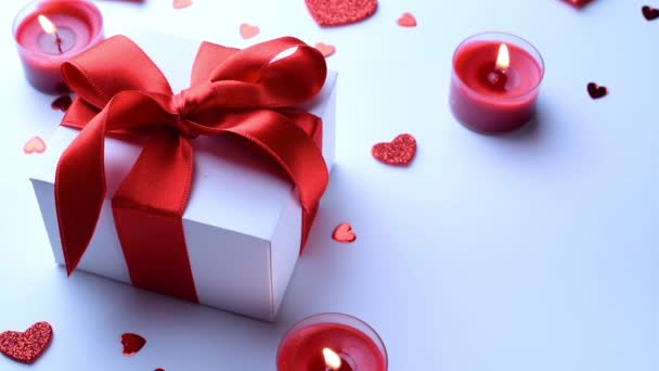 Valentijnsdag: rode liefde harten, romantische geschenkdoos, kaars op witte achtergrond. Romantische berichtsjabloon met kopieerruimte - Video