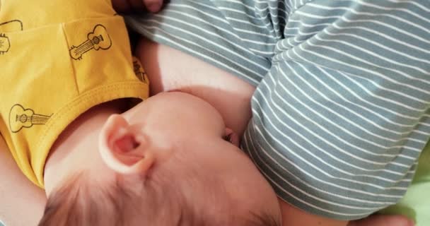 Mère allaitant son nouveau-né sur le canapé. Le lait maternel est un médicament naturel pour bébé. concept de famille, d'alimentation, d'enfant, d'alimentation et de parentalité - Séquence, vidéo