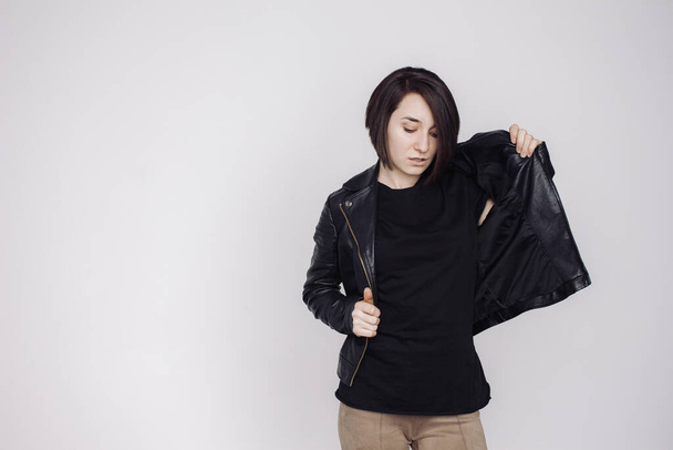 Portrait of smiling female in a black sweater and black jacket isolated on white background. - 写真・画像