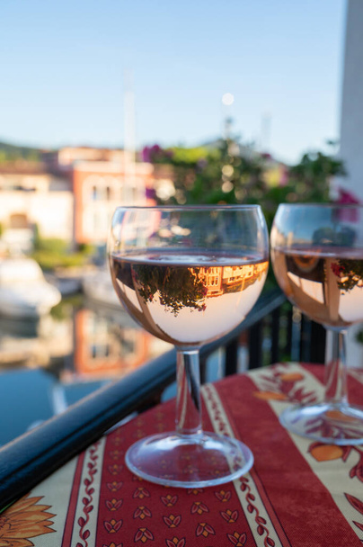Trinken des lokalen kalten Rosenweins im Sommer mit dem Hafen von Port Grimaud im Hintergrund, Provence, Var, Frankreich - Foto, Bild