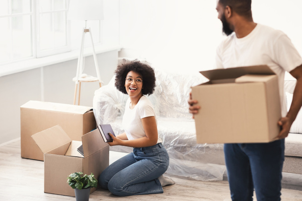 Schwarze Ehepartner packen für einen Hausumzug Kartons ins Haus - Foto, Bild