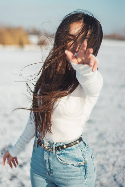 krásná bruneta natahuje ruku, zatímco stojí na ledu - Fotografie, Obrázek