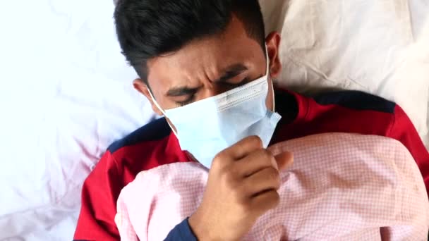 bovenaanzicht van zieke mannen met chirurgische gezichtsmasker op bed die hand op hand op borst leggen  - Video