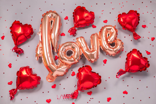 Palloncino d'aria beige pastello a forma di parola Amore con piccoli cuori rossi - Foto, immagini