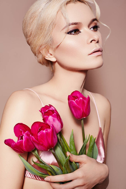 Beautiful sexy Blonde Woman with luxury retro Make-up. Girl with Spring Flowers Bouquet on Beige Background for any Celebrating. Fresh Style for Womans Day or Valentines - Fotografie, Obrázek