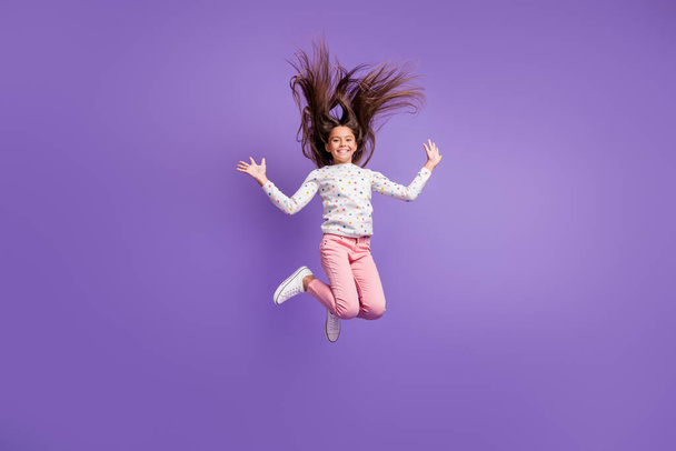 Full length body size photo small girl laughing jumping high throwing long hair in air isolated on vibrant purple color background - Fotoğraf, Görsel