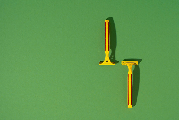 Disposable razor on green background, studio shot - Photo, image