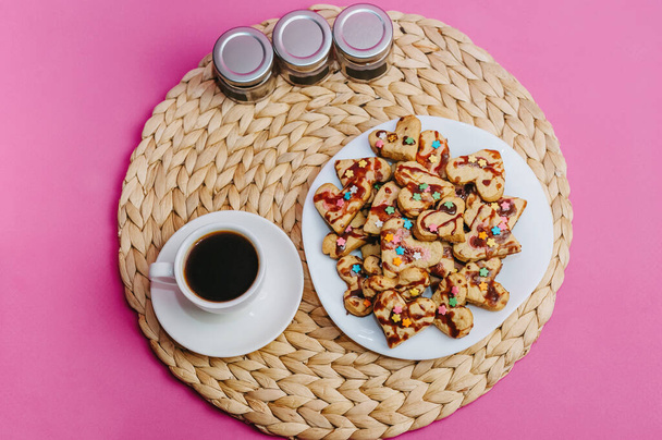 Tasse Kaffee, hausgemachte Plätzchen und Küchenutensilien auf rosa Hintergrund. - Foto, Bild