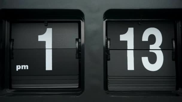 Flip clock Números blancos sobre fondo negro tiempo estelar 01.00 pm. - Imágenes, Vídeo