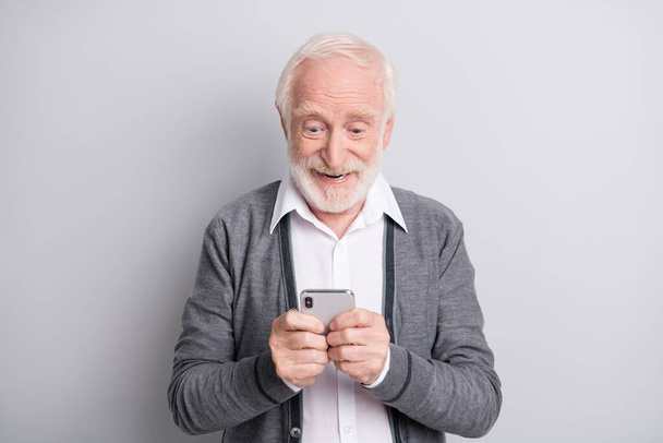 Portrait of old white hair optimistic man type telephone wear dark sweater isolated on grey background - Foto, immagini