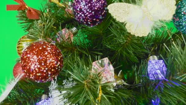 Un hermoso árbol de Navidad está girando sobre un fondo verde - Metraje, vídeo