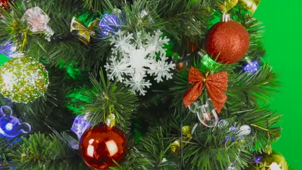 Hermoso árbol de Navidad está girando sobre un fondo verde - Metraje, vídeo