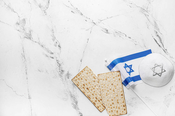 Jüdische Fladenbrotmatze zum Pessach, Mütze und Fahne Israels auf hellem Hintergrund - Foto, Bild
