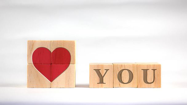 Red hearts and letters are displayed on square wooden blocks. Indicate love. - Foto, afbeelding