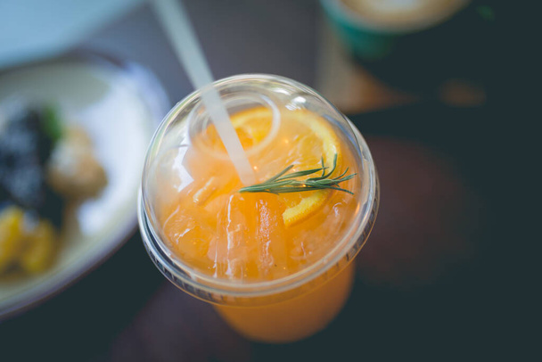 Imagen de un zumo de naranja recién exprimido con paja para beber en el desayuno - Foto, imagen