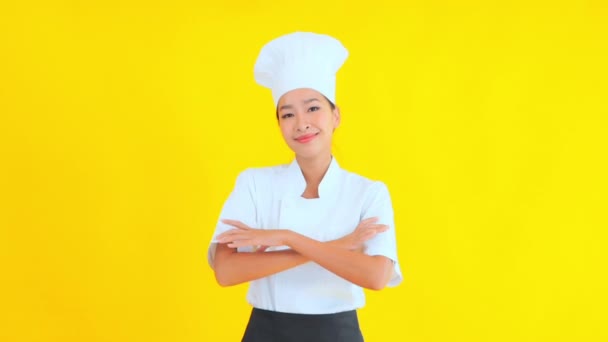 portret van mooie jonge Aziatische chef-kok op gele achtergrond - Video