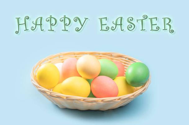 Gros plan des œufs de Pâques colorés dans le panier. Joyeux texte de Pâques. Œufs de Pâques colorés faits à la main dans le panier - Photo, image