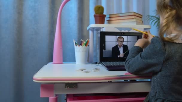 Óvodáskorú gyermek lány távolság online oktatás otthon, tanuló néz videó leckéket laptop - Felvétel, videó