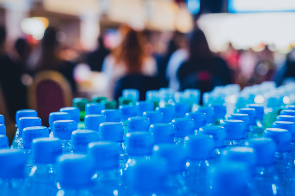 Photo horizontale d'une multitude de bouchons d'eau bleus sur une conférence d'affaires ou un séminaire, attendant les participants assoiffés. - Photo, image