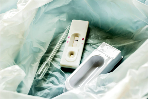 Strisce per test di gravidanza con attrezzature già in uso attraverso i sacchi della spazzatura. - Foto, immagini