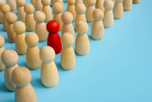 Be different in the crowd. Unique red figure with wooden ones. - Foto, Imagem