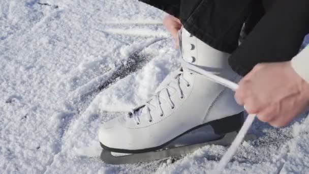 Close up of woman puts on skates outdoors - Footage, Video