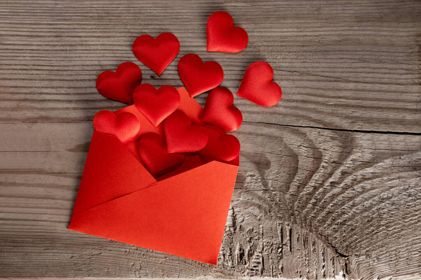 Ystävänpäivä rakkauskirje, kirjekuori punaisella sydämellä kasa levinnyt puinen tausta - Valokuva, kuva