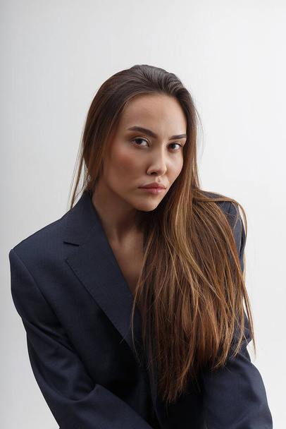 junge attraktive asiatische Frau im blauen Anzug isoliert auf weißem Studiohintergrund - Foto, Bild