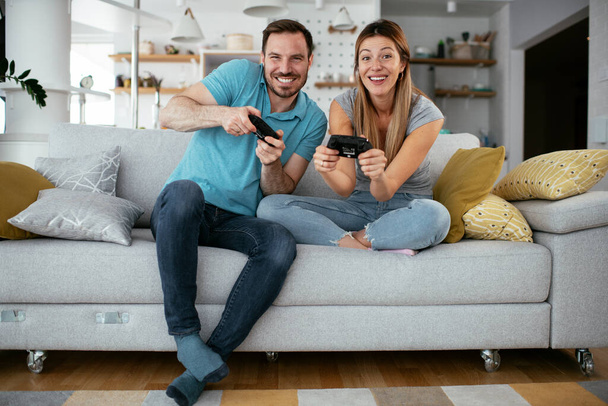 ζευγάρι που παίζει βιντεοπαιχνίδια στο σπίτι  - Φωτογραφία, εικόνα