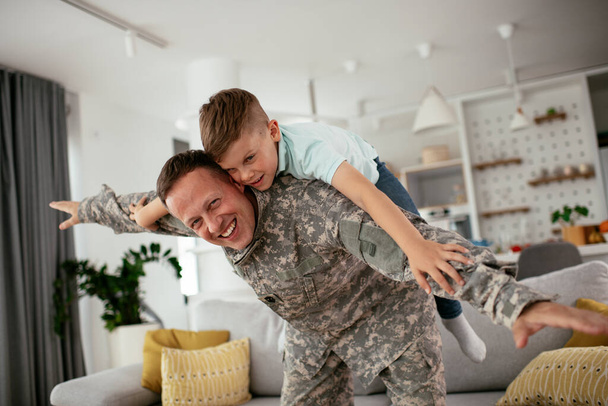 militar jugando con hijo en casa  - Foto, imagen