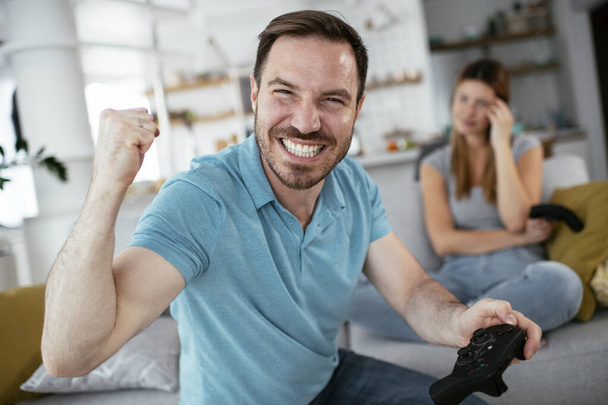 couple playing video games at home  - Фото, изображение