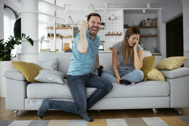 ζευγάρι που παίζει βιντεοπαιχνίδια στο σπίτι  - Φωτογραφία, εικόνα