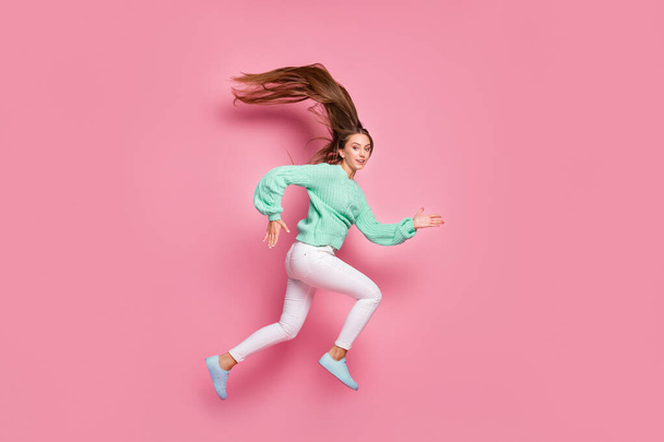 Full size photo of attractive sportive person jump run fast teal sweater isolated on pink color background - Foto, imagen
