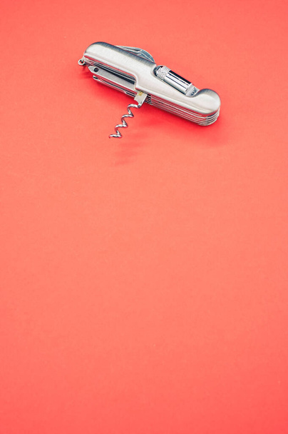 A vertical isolated shot of the multifunctional pocket knives on a pink background - Foto, Imagem