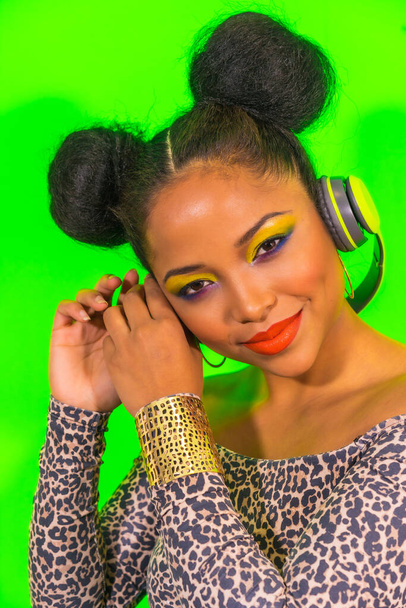 A lovely smiling hipster girl with bright makeup and two tails hairstyle enjoying music with headphones - Foto, Imagem