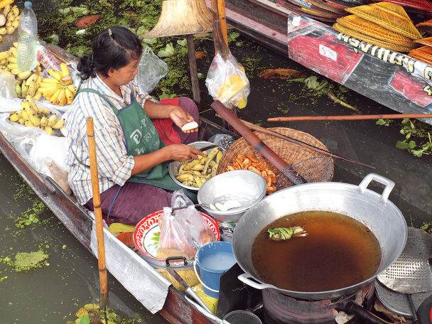 RATCHABURI, THAILAND-SEPTEMBER 2013: Local peoples sell fruits, food and products at Damnoen Saduak floating market, on September 7 2013 in Ratchaburi, Thailand. Dumnoen Saduak is a very popular tourist
 - Фото, изображение