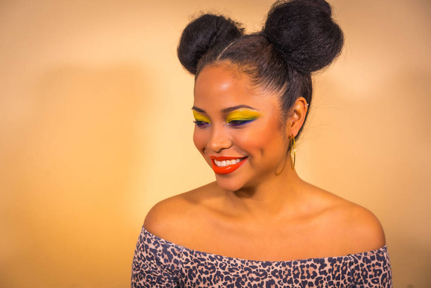 A closeup of a positive young hipster girl with bright makeup and two tails hairstyle wearing a leopard print dress with open shoulders - Photo, image