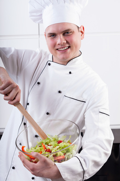 Cheerful chef mixing salad - Fotoğraf, Görsel
