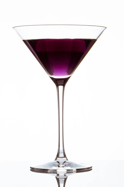 A vertical closeup of a glass of purple cocktail isolated on a white background - Zdjęcie, obraz