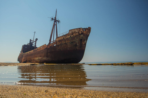 Dimitrios shipwreck in  Gythio, Greece. A partially sunken rusty and metal shipwreck decaying through time on a sandy beach on a sunny day. Famous shipwreck in greece. - Photo, Image