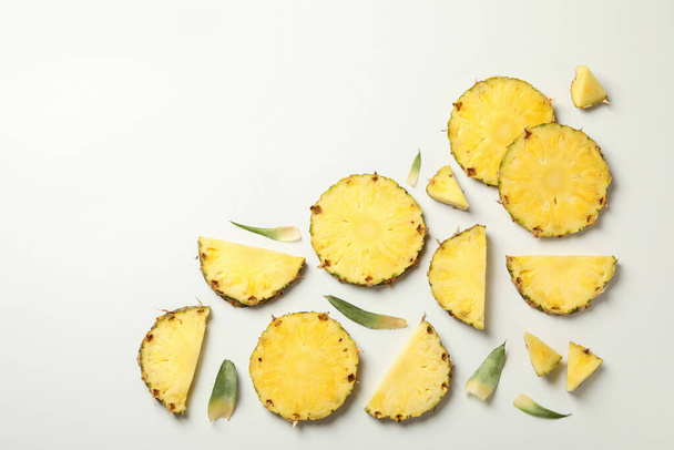 Pose plate avec tranches d'ananas sur fond blanc, vue de dessus - Photo, image