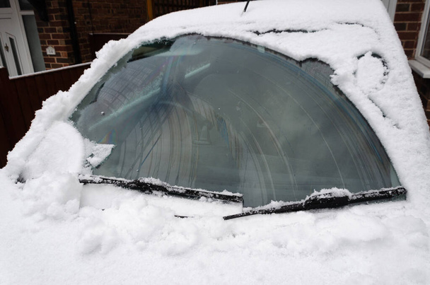 Nieve despejado de un parabrisas del coche mediante la operación de los limpiaparabrisas. - Foto, imagen
