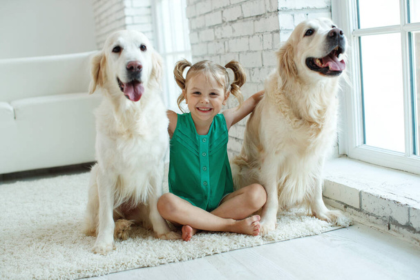 Glückliches Kind mit Hund. Porträt eines Mädchens mit einem Haustier. Labrador Retriever zu Hause.  - Foto, Bild