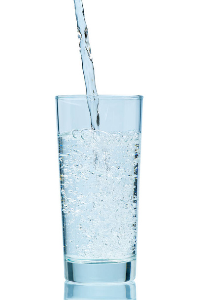 Öntöm a vizet. Friss, tiszta ivóvíz öntése az üvegbe. fehér alapon izolálva - Fotó, kép