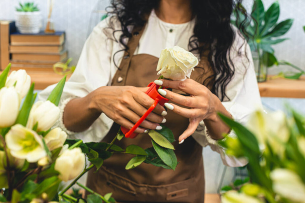 Attractive young woman florist is working in a flower shop. - Foto, Bild