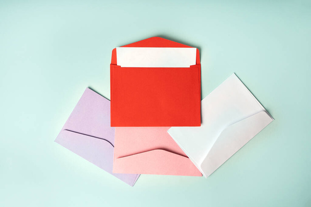 Enveloppes colorées sur fond bleu. Composition minimaliste, vue de dessus, concept de courrier - Photo, image