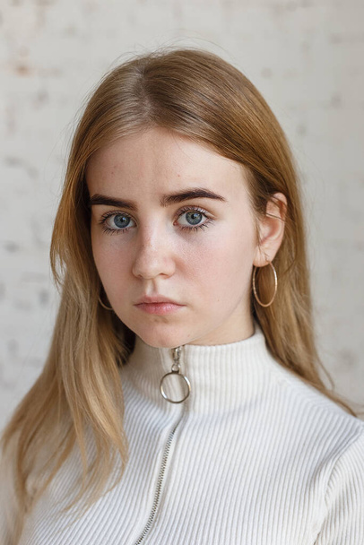 close-up retrato de modelo adolescente pensativo com olhos azuis vestindo camisola branca - Foto, Imagem
