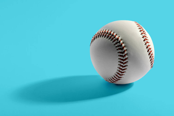 Nahaufnahme eines einzelnen Leder-Baseballs aus Rindsleder mit roten Nähten auf blauem Hintergrund - Foto, Bild