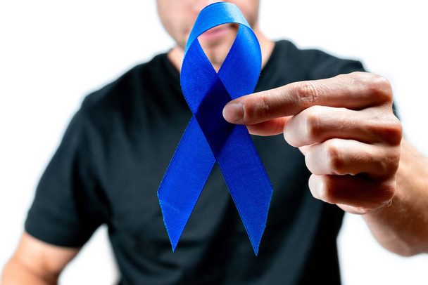 Modrá prostata. Rakovina vědomí u mužů zdraví. Hipsteři v černé košili s modrou stuhou v rukou izolovaných na bílém pozadí. November and International Mens Day - Fotografie, Obrázek